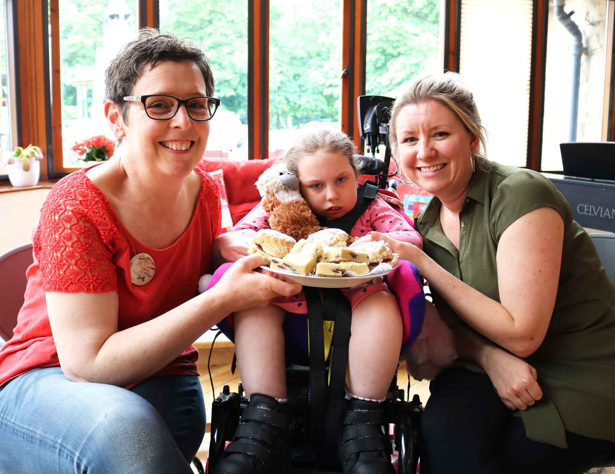 Martin House artist in residence Helen Scouller with Olivia Evans, nine, and her mum Hannah Evans preparing for the Big Bake