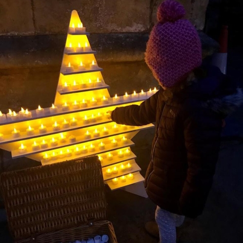 Saint Michael’s young supporter, lighting a candle in memory of her father, as part of last year’s Twilight Walk